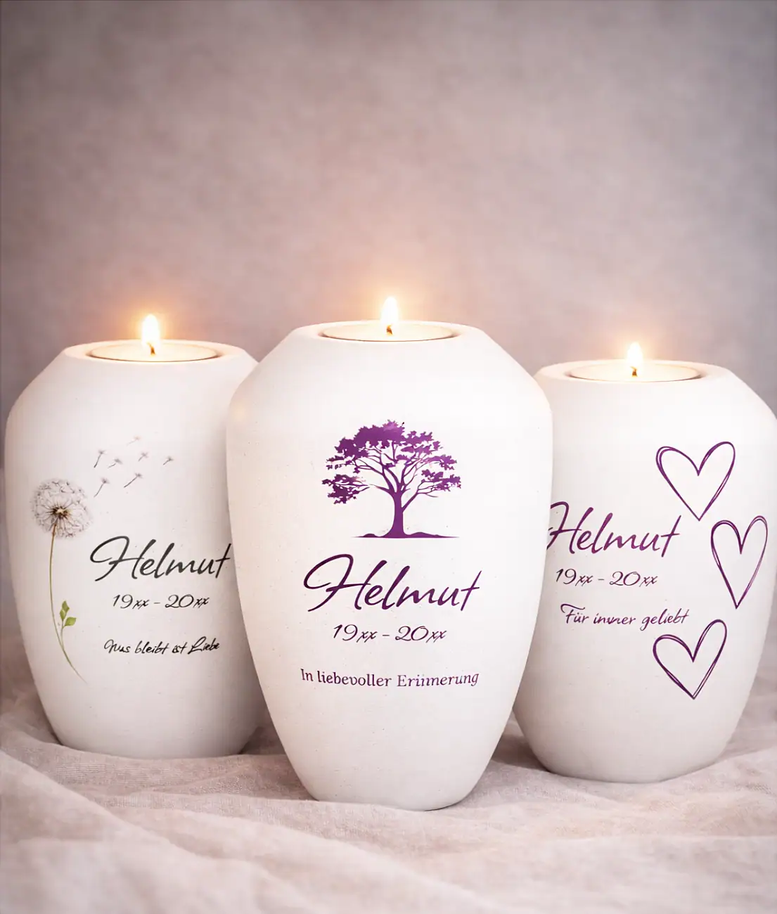 Drei personalisierte Gedenklichter mit brennendem Teelicht und verschiedenen Motiven – Pusteblume, Lebensbaum und Herzen